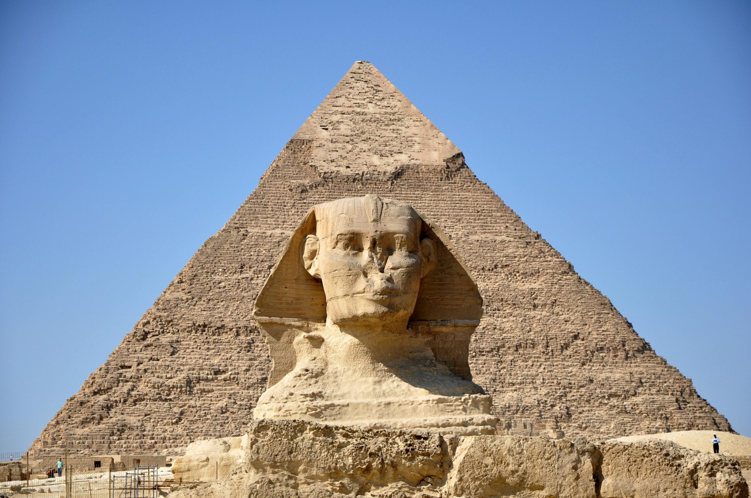 Iconic view of the Sphinx and Great Pyramid of Giza on a sunny day, showcasing ancient Egyptian architecture.