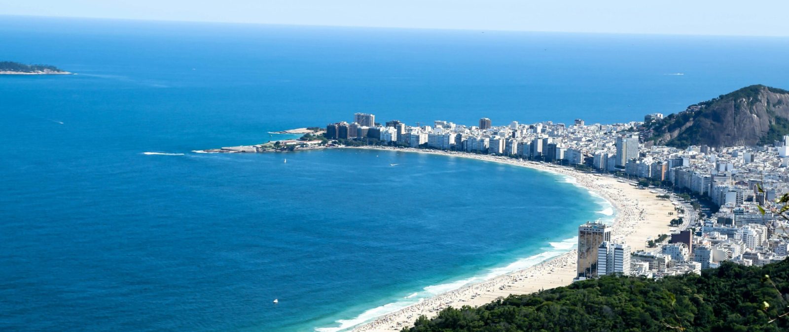 Stunning aerial view of Copacabana Beach and cityscape in Rio de Janeiro, Brazil, showcasing vibrant seaside life.